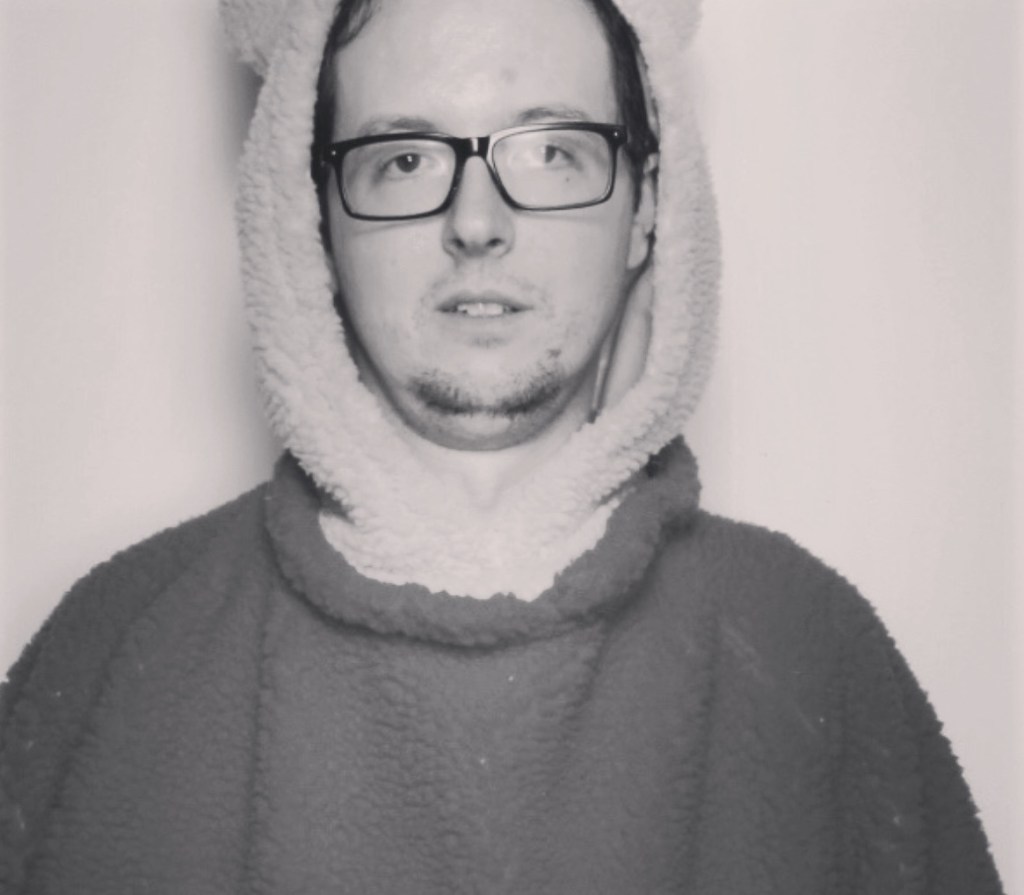 Dave in a teddy bear suit in a grayscale photo showing from just below the shoulders and up.